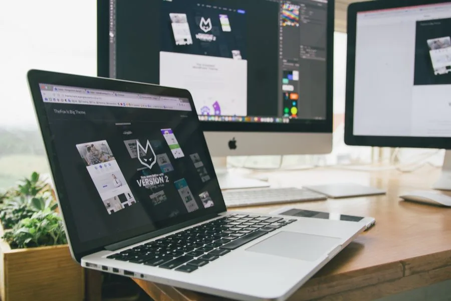 Notebook e monitores com um software de design de sites